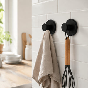 Matte black suction hook on kitchen backsplash holding utensils