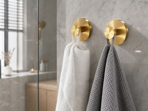 Gold suction hook on marble bathroom wall holding white towel