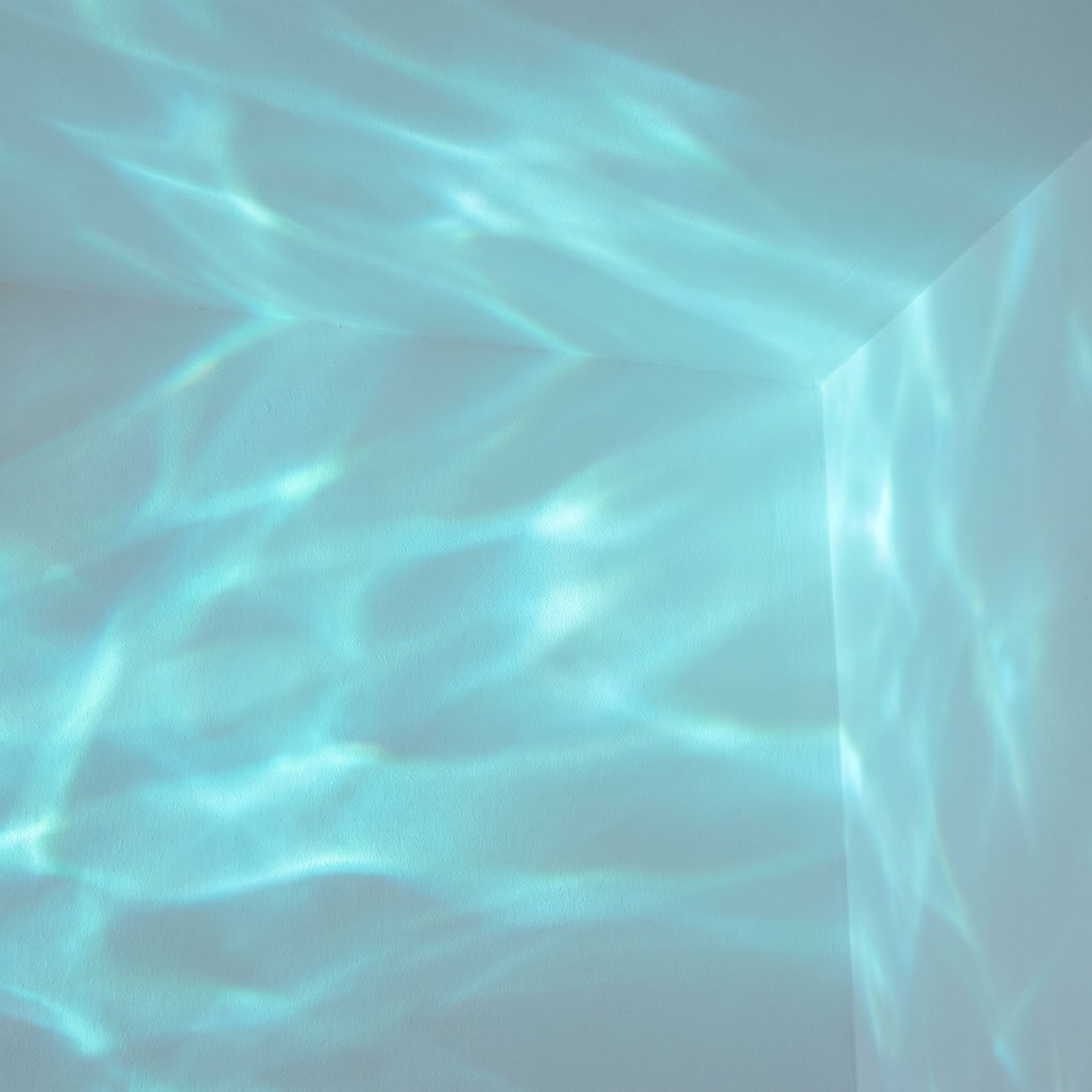 Cyan-teal aurora wave light pattern on wall and ceiling