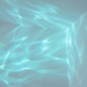 Cyan-teal aurora wave light pattern on wall and ceiling