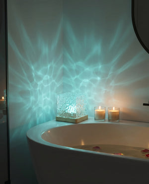 Cordless aurora wave lamp on bathtub edge with candles