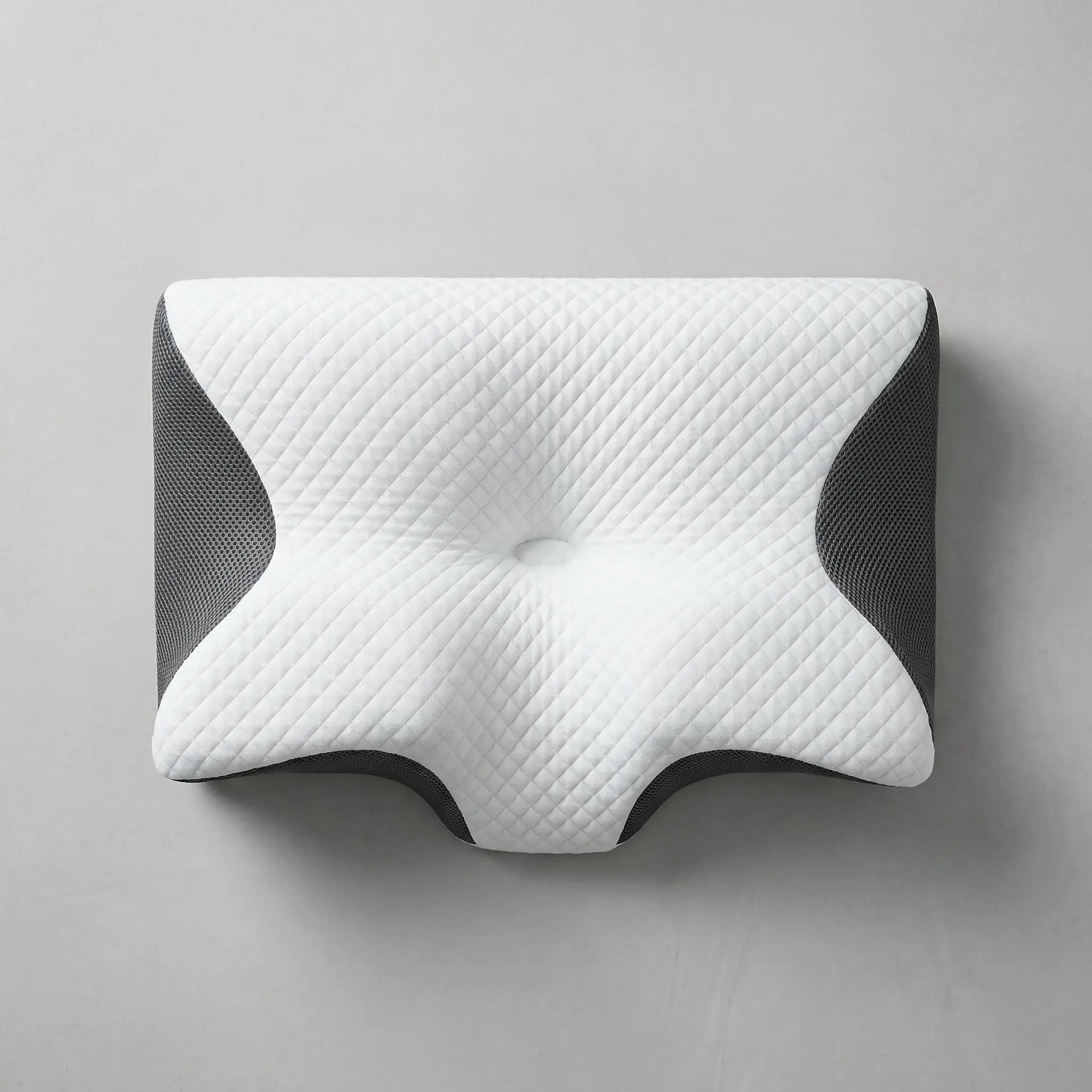 Light grey cervical pillow flatlay on a linen sheet