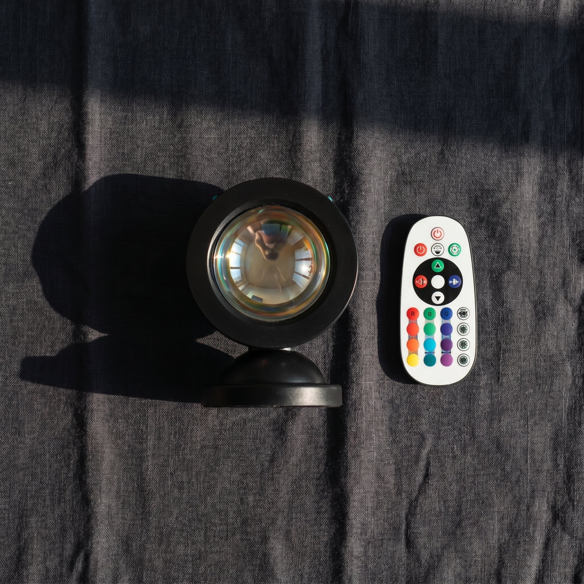 Sunset Projection Light and remote control flat lay on dark linen